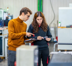 quality-control-workers-standing-talking-while-using-tablet-in-print-shop
