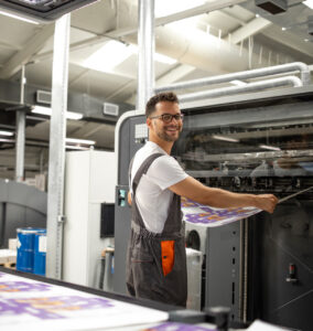 worker-taking-imprint-from-modern-printing-machine-color-matching-quality-control